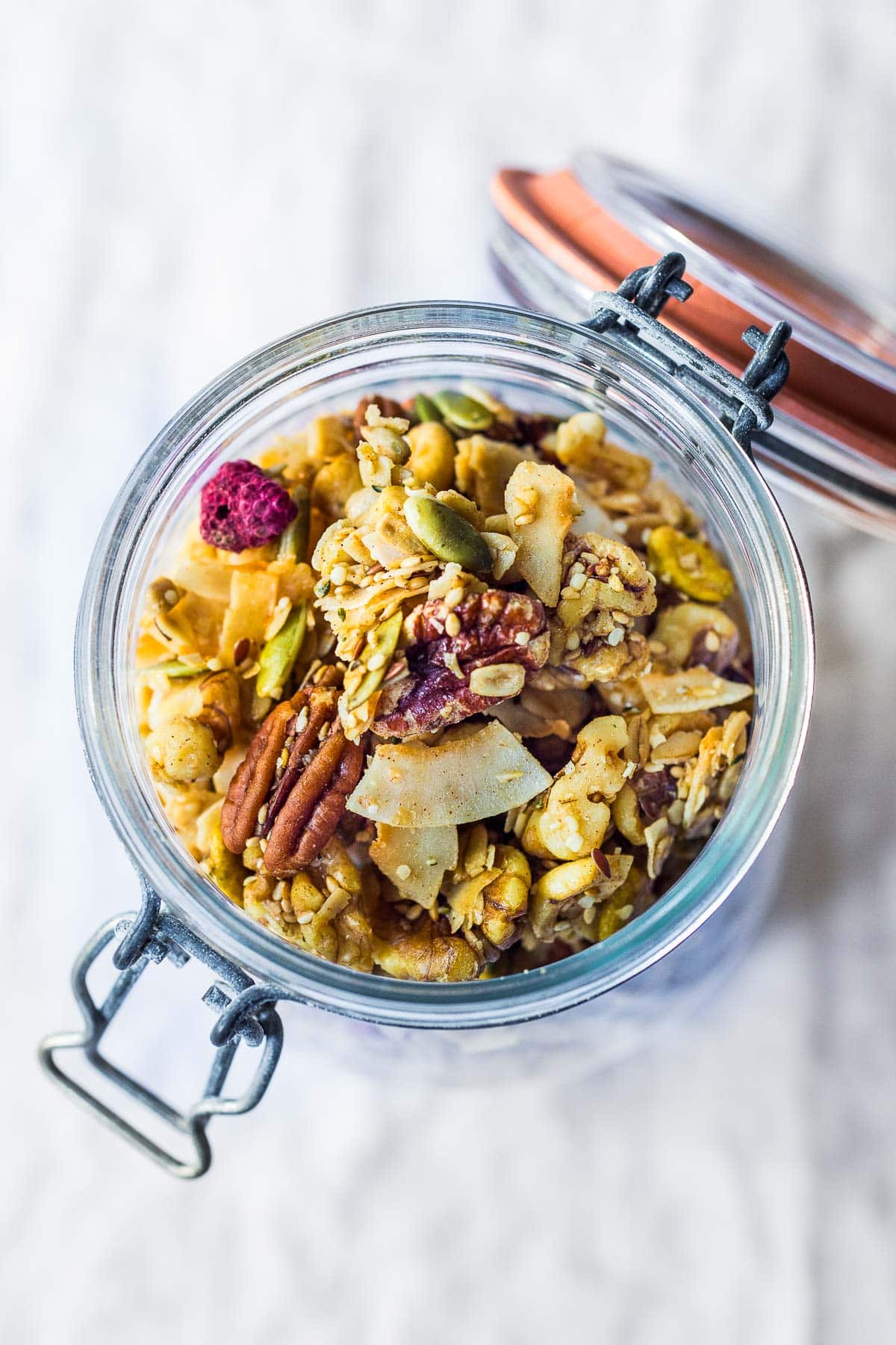 clusters of nutty vegan granola in a jar.