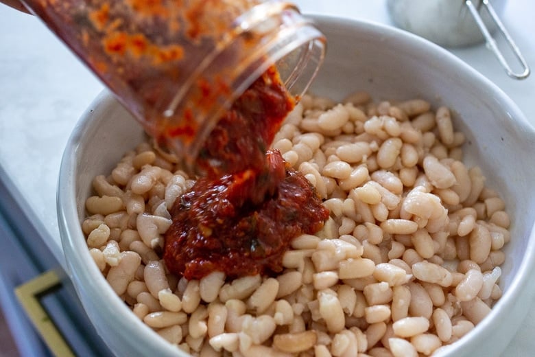 adding marinara sauce to the cannellini beans