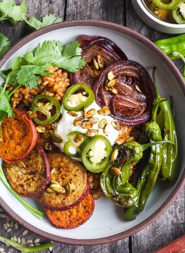 Healthy and flavorful Mexican Rice made with brown rice, topped with sheet-pan roasted yams, red onions, and shishito peppers.  Top with pickled jalapeños and pumpkin seeds for a comforting delicious vegan meal. #mexicanrice