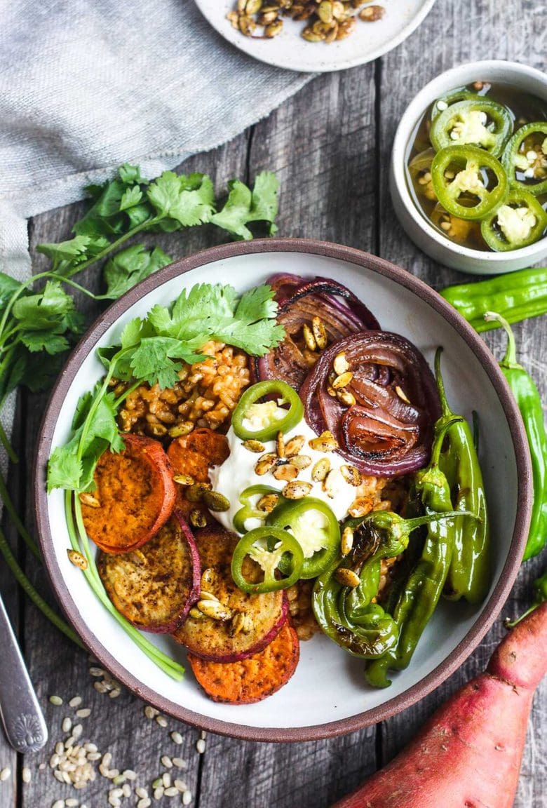Healthy and flavorful Mexican Rice made with brown rice, topped with sheet-pan roasted yams, red onions, and shishito peppers.  Top with pickled jalapeños and pumpkin seeds for a comforting delicious vegan meal. #mexicanrice