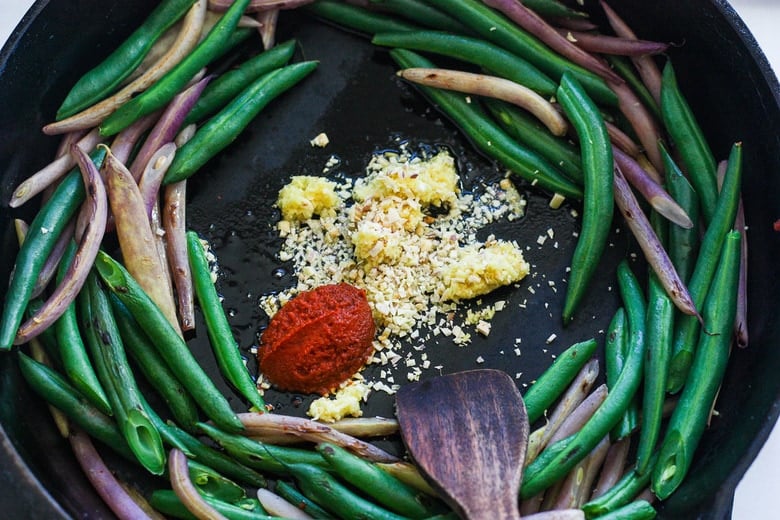 stir frying green beans, garlic, ginger and chili paste