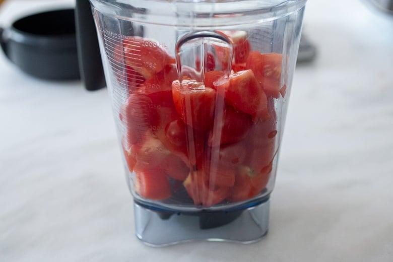 Quarter the tomatoes and add to a blender 