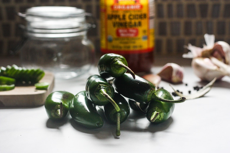 ingredients in pickled jalapeños on a counter.