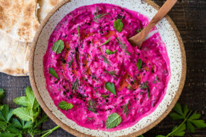 Vibrant Beet Tzatziki made with grated beets, cucumber, Greek yogurt and fresh herbs- a festive appetizer or complementary side dish to Mediterranean-inspired meals.  Vegan-adaptable!