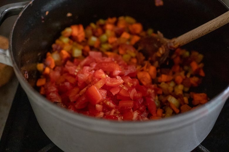 adding tomatoes to the bolognese