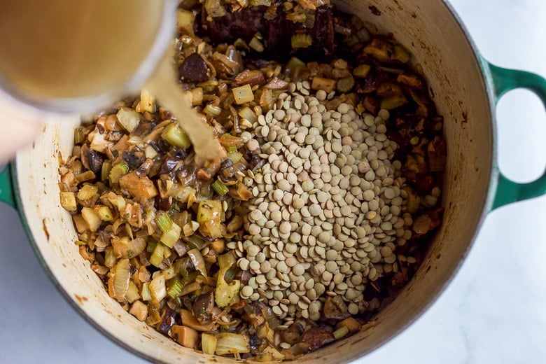 Adding vegetable broth and lentils.