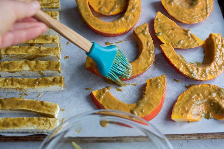 brushing sauce on squash and tofu