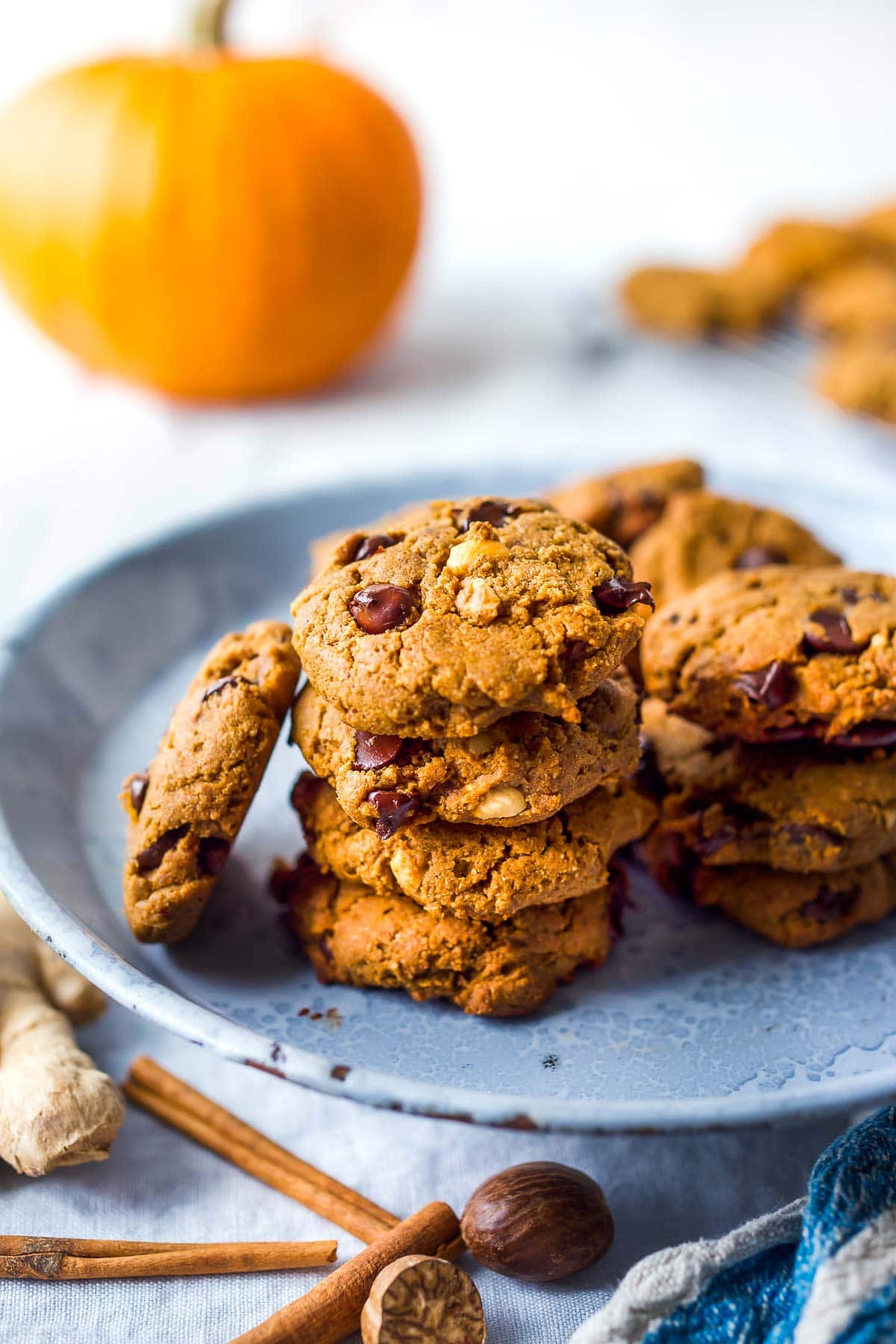 Pumpkin chocolate chip cookies stacked on a blue plate.