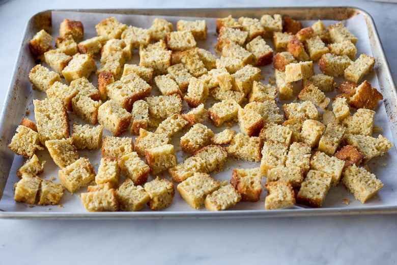 cornbread cut in cubes on baking tray.