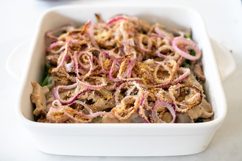 topping the green bean casserole with crispy onions