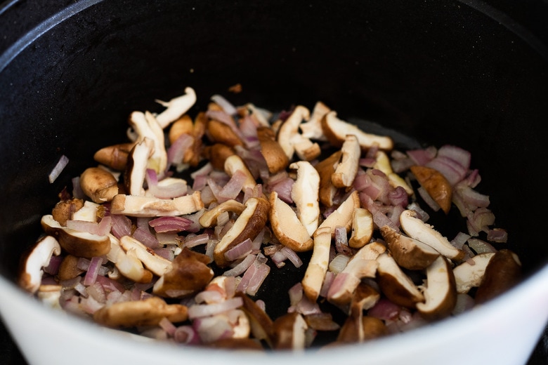 mushrooms and onions sautéing in a pan