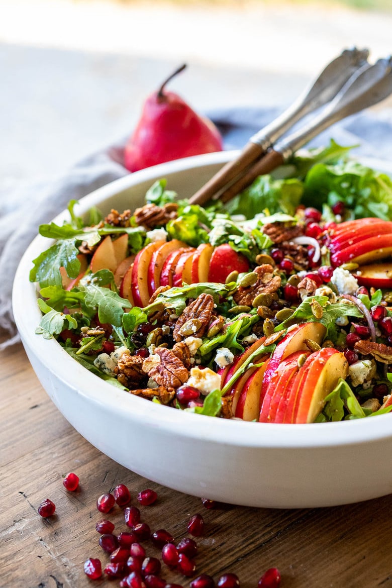 This Pear Salad is the perfect side for a fall gathering or the holiday table. Juicy ripe pears, arugula, spiced nuts, pomegranate seeds, dried currants and gorgonzola are all tossed in a flavorful Vanilla Fig Dressing to create the most delicious balance of flavors. 