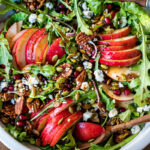 This Pear Salad is the perfect side for a fall gathering or the holiday table. Juicy ripe pears, arugula, spiced nuts, pomegranate seeds, dried currants and gorgonzola are all tossed in a flavorful Vanilla Fig Dressing to create the most delicious balance of flavors.