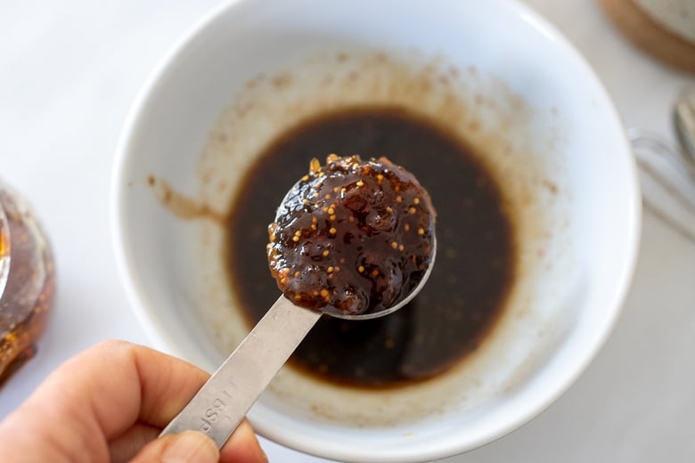 Adding fig jam into the bowl for the fig dressing.