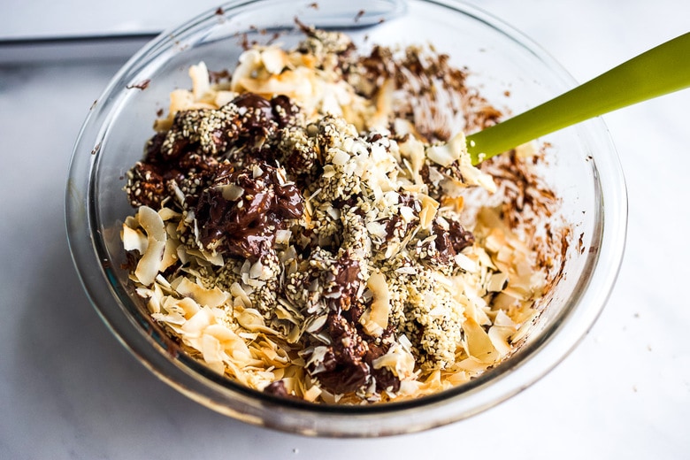 mixing coconut, sesame seeds, cashews and chocolate 