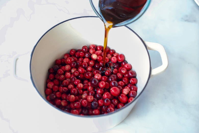 adding maple syrup to cranberries