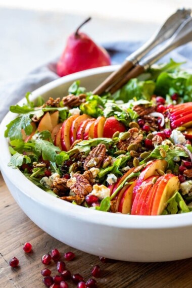 This Pear Salad is the perfect side for a fall gathering or the holiday table. Juicy ripe pears, arugula, spiced nuts, pomegranate seeds, dried currants and gorgonzola are all tossed in a flavorful Vanilla Fig Dressing to create the most delicious balance of flavors. 