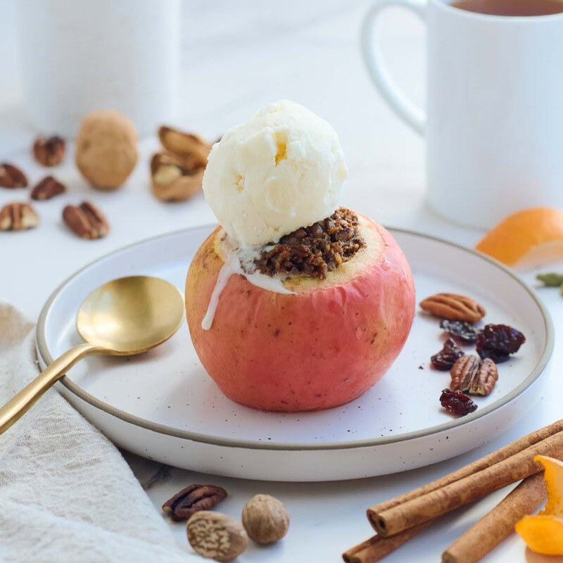 These Baked Apples are a cozy, fall dessert (or delicious homey breakfast!) Filled with toasted nuts and dates, dried cherries, cinnamon, and orange zest, they are maple-sweetened with no refined sugar! This baked apples recipe is vegan and gluten-free.