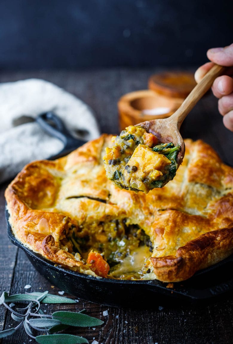 Veggie Pot Pie with roasted butternut squash, lentils, and kale topped with a golden puff pasty crust - a cozy vegan dinner recipe the whole family will enjoy.