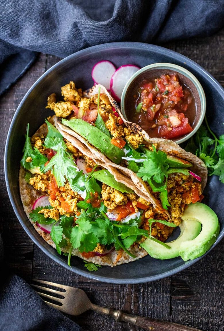 Vegan Breakfast Tacos are made with flavorful scrambled tofu, infused with Mexican spices, served up in warm tortillas with avocado, radishes, salsa & cilantro.