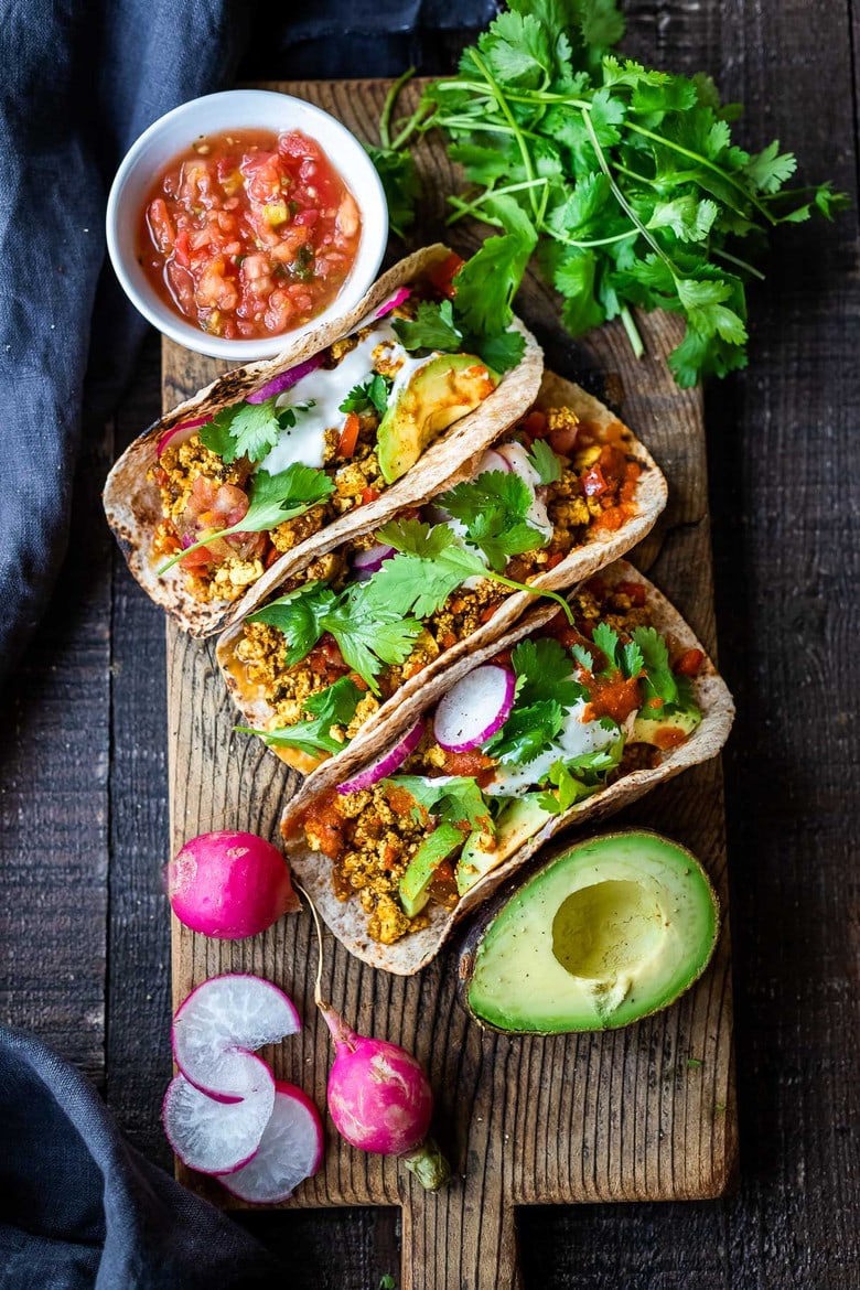 Vegan Breakfast Tacos are made with flavorful scrambled tofu, infused with Mexican spices, served up in warm tortillas with avocado, radishes, salsa & cilantro.