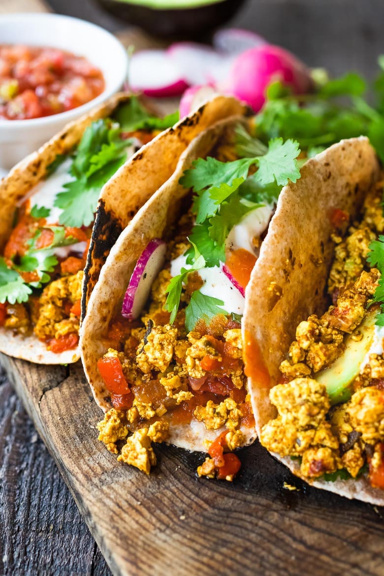 Vegan Breakfast Tacos are made with flavorful scrambled tofu, infused with Mexican spices, served up in warm tortillas with avocado, radishes, salsa & cilantro.