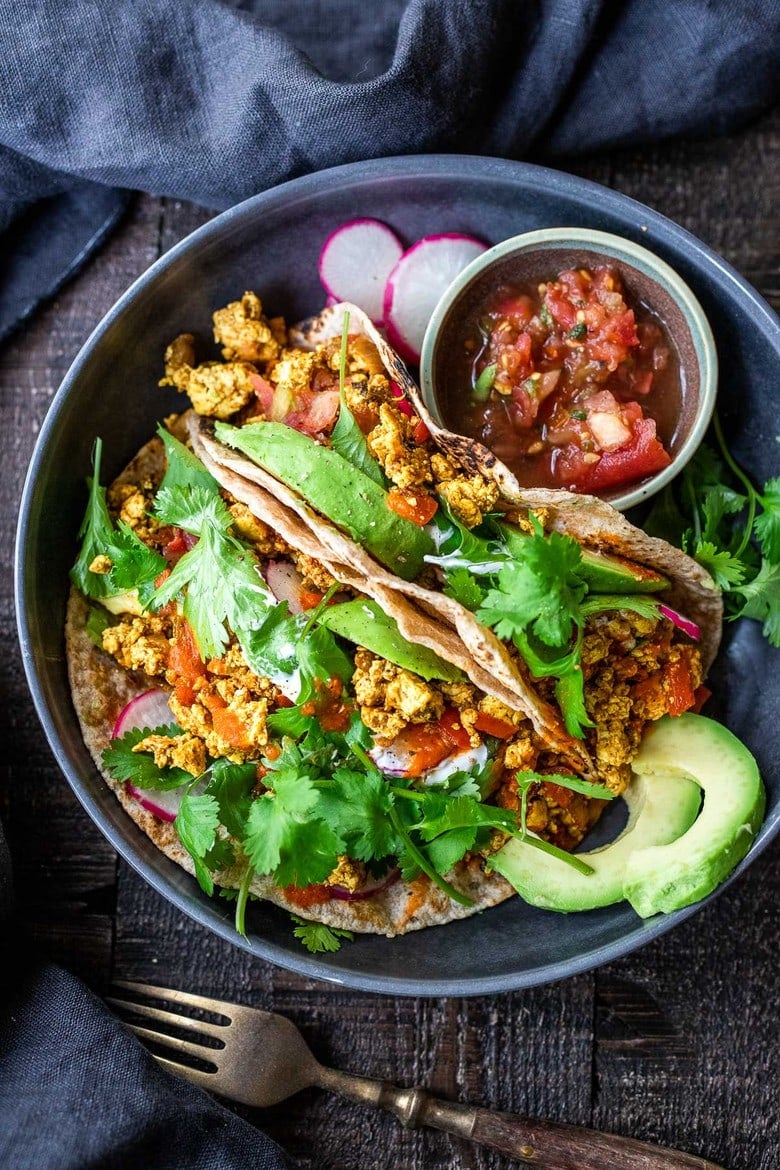 Vegan Breakfast Tacos are made with flavorful scrambled tofu, infused with Mexican spices, served up in warm tortillas with avocado, radishes, salsa & cilantro.