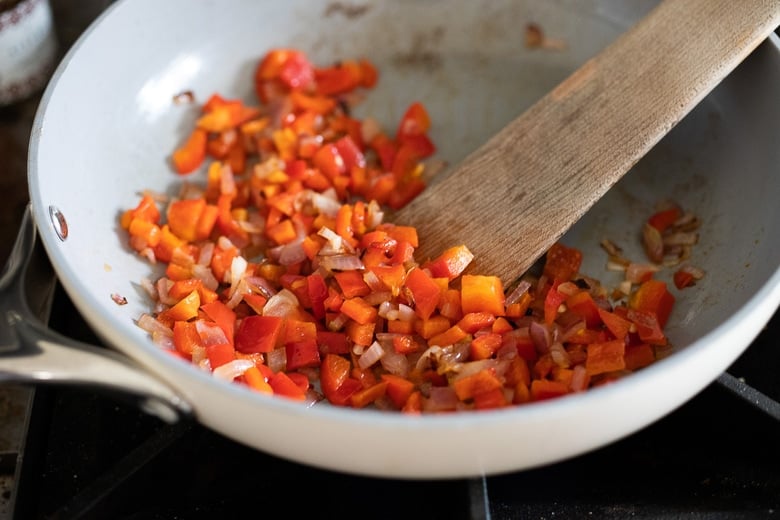 making breakfast tacos-onions and bell peppers being sautéed. 