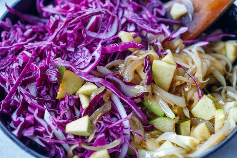 adding cabbage into the pan