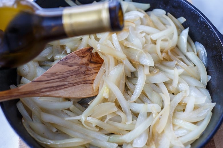 adding olive oil to onions 