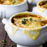 A cozy, comforting, classic recipe for French Onion Soup with caramelized onions in rich deep broth topped with toasty croutons and melted gruyere.  Vegan and Vegetarian Adaptable! #frenchonionsoup