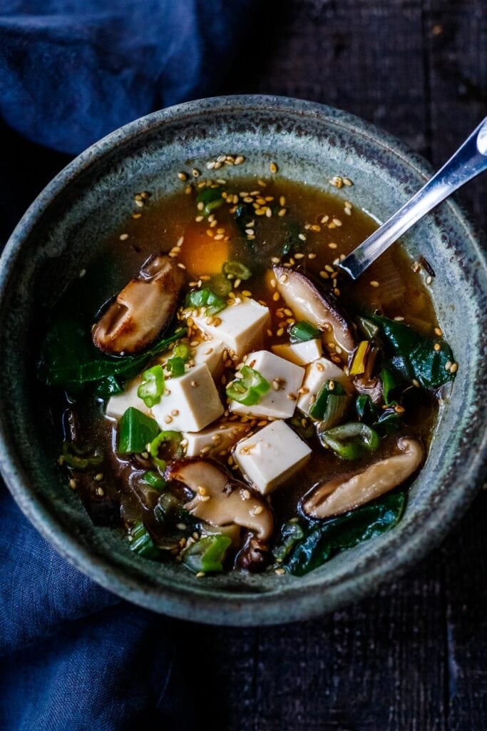 20-minute Miso Soup Recipe with leeks, shiitake mushrooms, wilted greens, and tofu makes for a fast and easy weeknight dinner. Full of flavor and nutrients it is highly nourishing while remaining light and lean. Vegan and GF adaptable.