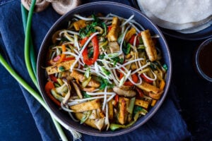 This Moo Shu Tofu recipe is loaded with tender-crisp vegetables and crispy tofu tucked into a tortilla or rice pancake, slathered with a tangy hoisin sauce.  A quick and easy weeknight dinner!  Vegan and Gluten-Free.