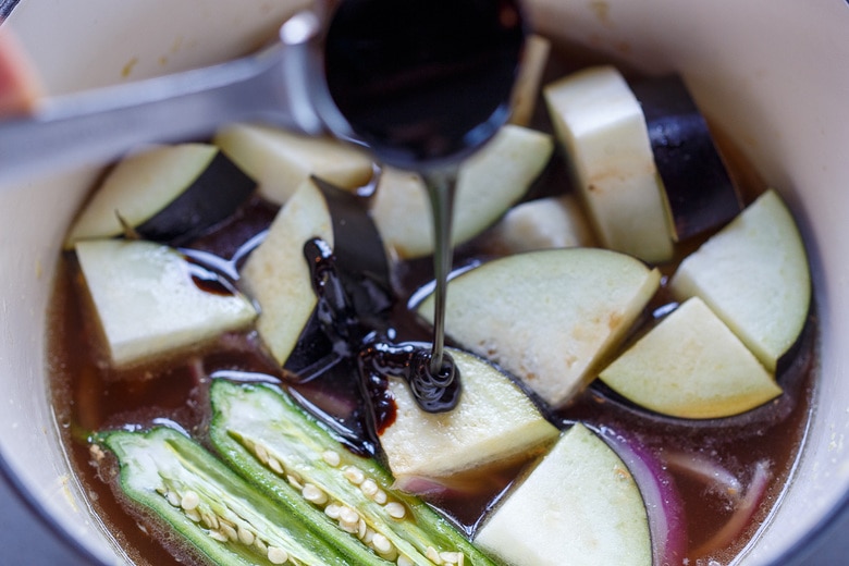 Eggplant, broth and tamarind in soup pot.