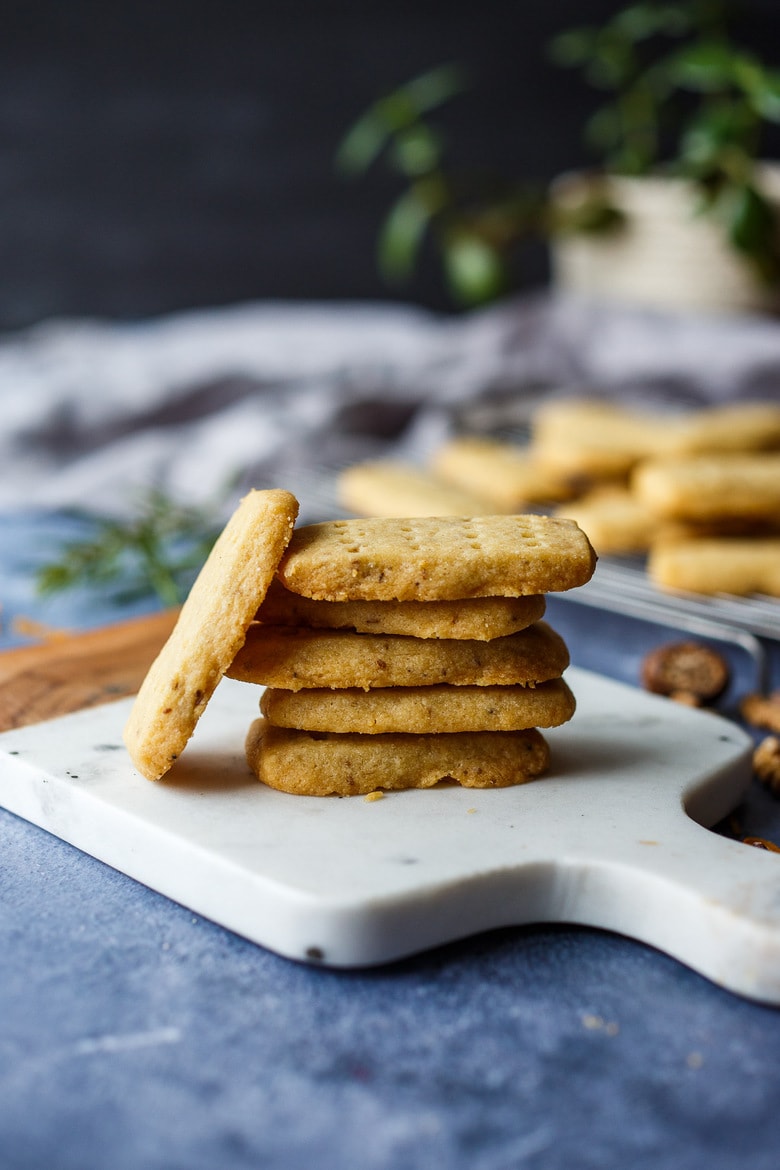 stack of shortbread cookies with one cookie leaning against the stack.