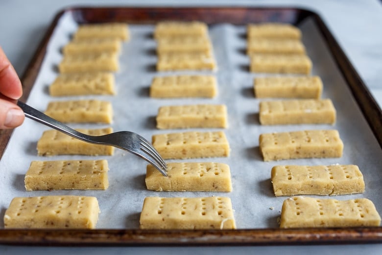 scoring the shortbread cookies before baking with a fork.