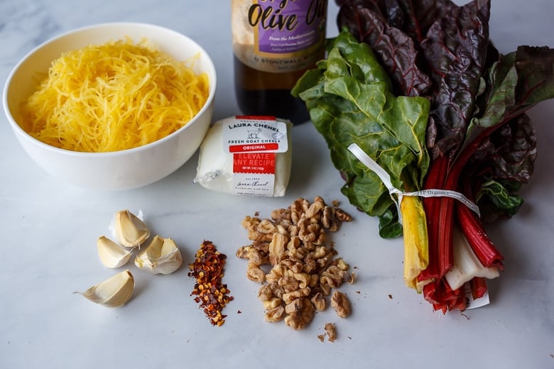 ingredients for spaghetti squash recipe: garlic, olive oil, chard, walnut, & goat cheese 