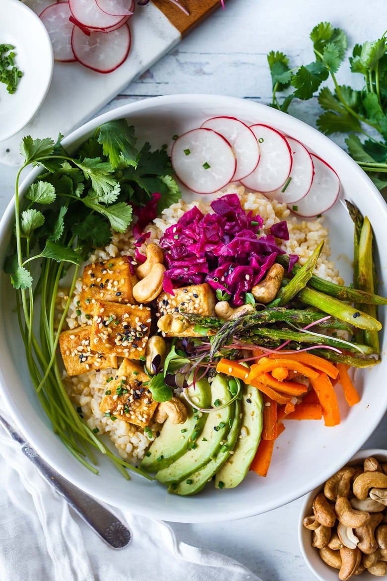 This simple Miso Tofu Bowl comes together with minimal effort.  Roasting together on a sheet pan, tofu, carrots and asparagus are tossed with a savory miso marinade- infused with vibrant orange and ginger. The glaze doubles as dressing to finish bowl the bowl!