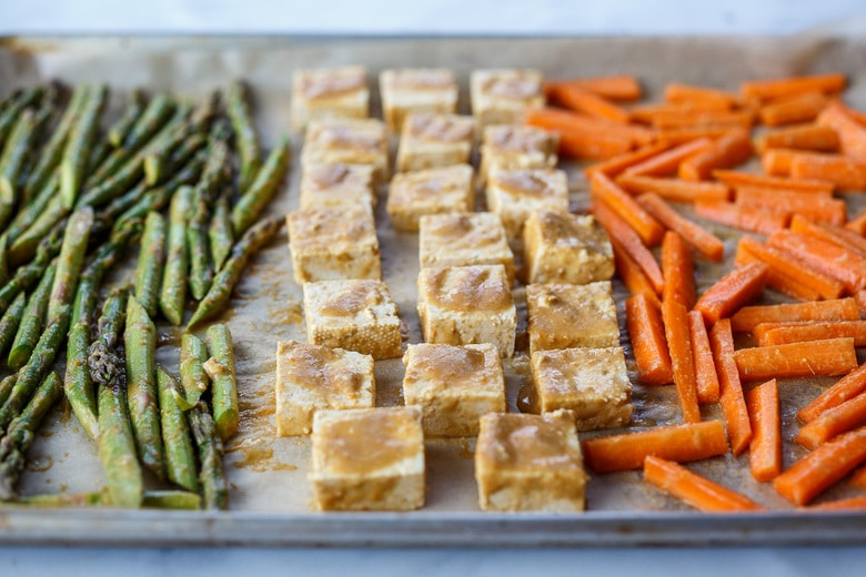 placing veggies and tofu on a sheet pan 