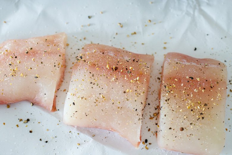 seasoning the halibut with salt and pepper 