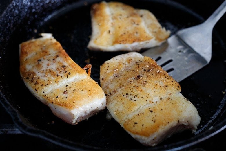 pan-searing the halibut in a skillet with olive oil