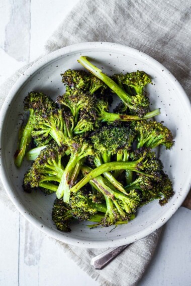 How to make Crispy Oven Roasted Broccoli - perfect as a simple side dish or use to enhance other dishes.  Baking in a hot oven yields tender-crisp broccoli in under 30 minutes. Fast and EASY Recipe!