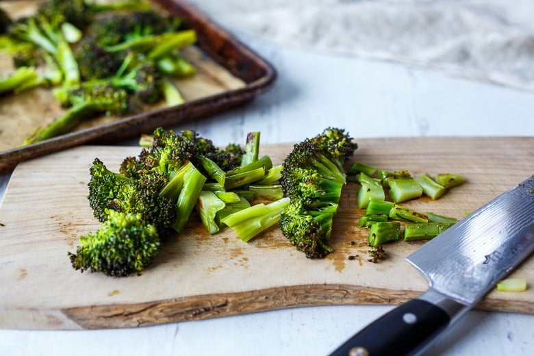 chopping roasted broccoli into bite sized pieces