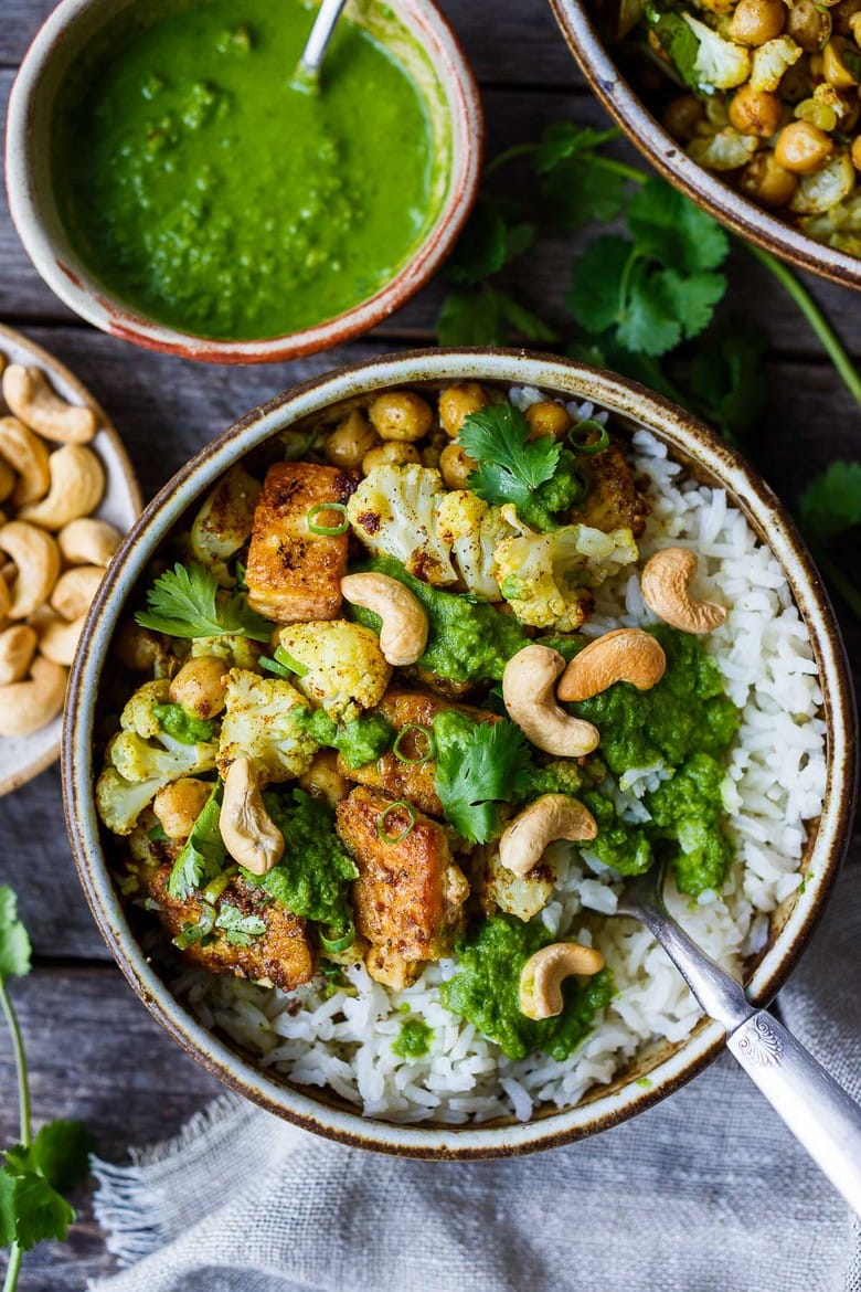 35 Delicious Indian Recipes to Make at Home | Savory oven-roasted Indian Cauliflower, Chickpea, and Tofu Bowls served over fluffy basmati rice with Cilantro Mint Chutney, seasoned with a simple Madras Curry dressing. A simple dish rich with fragrant spice and amazing flavor.  Healthy,  flavorful, and vegan! (Updated 4/22)