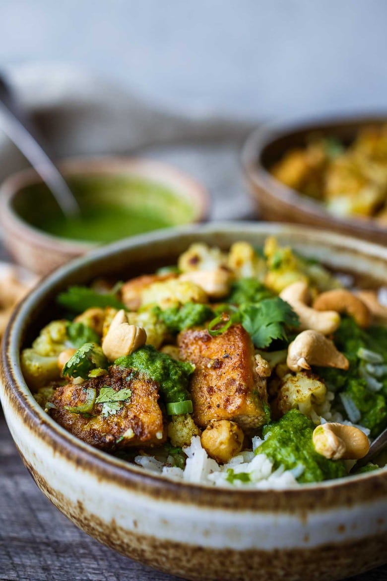 Savory oven-roasted Indian Cauliflower, Chickpea, and Tofu Bowls served over fluffy basmati rice with Cilantro Mint Chutney, seasoned with a simple Madras Curry dressing. A simple dish rich with fragrant spice and amazing flavor.  Healthy,  flavorful, and vegan! (Updated 4/22)