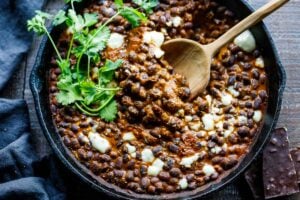 Savory Black Beans baked in a quick and easy Mexican Mole Sauce topped with queso fresco cheese (optional)- serve this as a delicious side dish for your Mexican Fiesta or as a flavorful base for healthy bowls.
