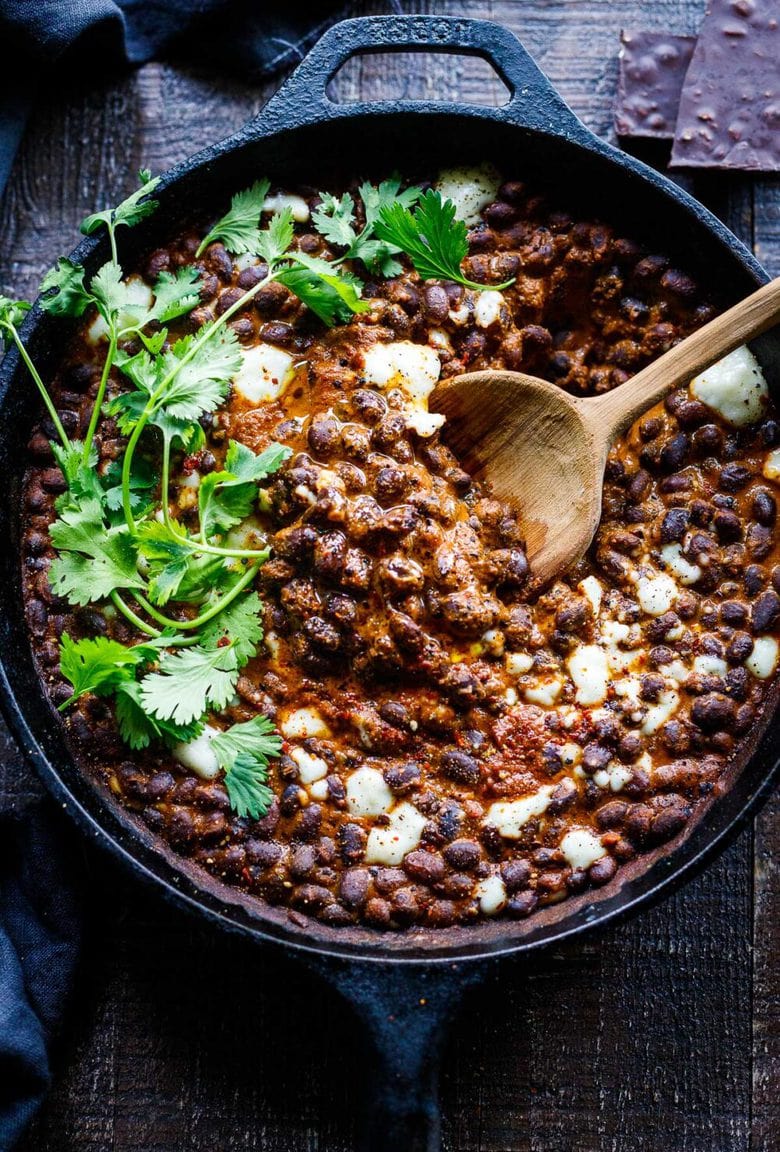 Savory Black Beans baked in a quick and easy Mexican Mole Sauce topped with queso fresco cheese (optional)- serve this as a delicious side dish for your Mexican Fiesta or as a flavorful base for healthy bowls.
