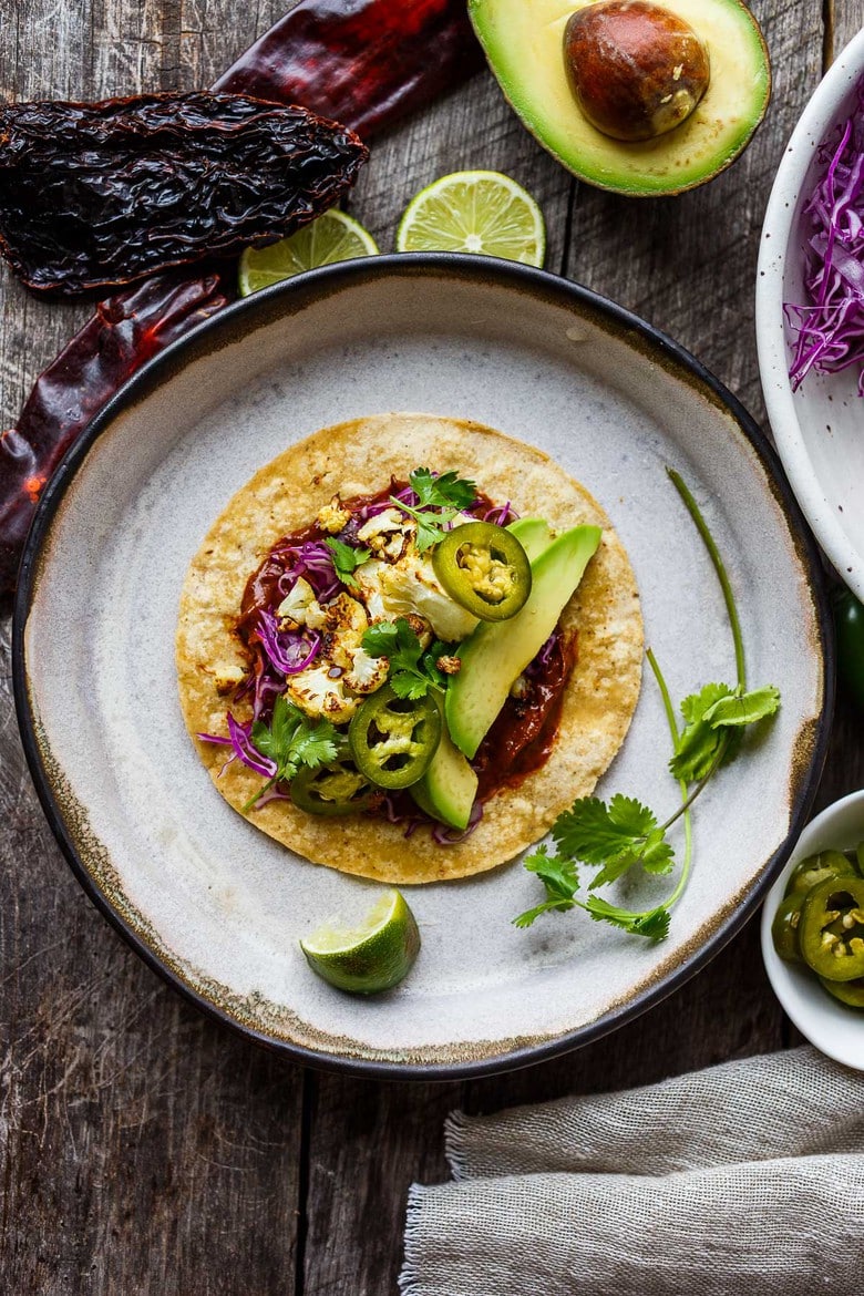 Roasted Cauliflower Tacos with quick and easy Mole Rojo sauce!  These healthy vegan tacos are full of satisfying flavor and fresh crunchy ingredients.