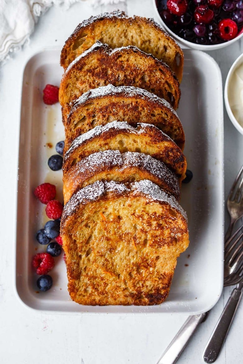 French toast in a serving dish lined up and overlapping.