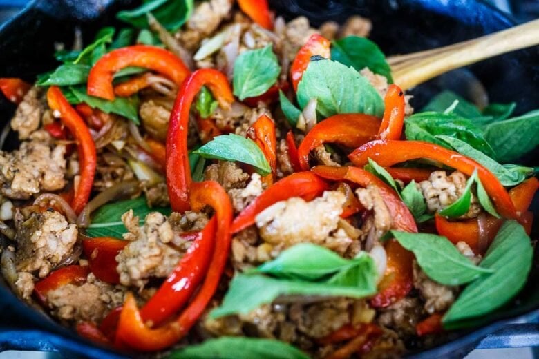 Adding basil into the Thai basil chicken.